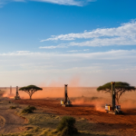 Explorations-Bohranlagen in einer afrikanischen Savannenlandschaft bei goldenem Abendlicht