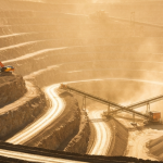 Tagebau-Goldmine aus der Vogelperspektive mit terrassierten Felsformationen und schwerem Gerät