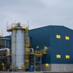 Uranverarbeitungsanlage unter bewölktem Himmel in stahl-blauer Industriekulisse