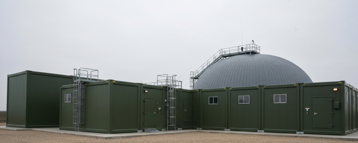 Modulare Kernreaktoranlage unter bedecktem Himmel in militärgrüner Industrieumgebung