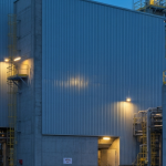 Uranverarbeitungsanlage bei Blaustunde mit kühler Industriebeleuchtung und stählernen Betonbauten