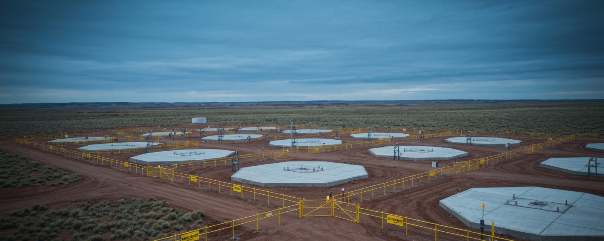 Luftaufnahme einer ISR-Urananlage in Wyoming mit Bohrkopf-Reihen und Sicherheitszäunen unter stahlblauem Himmel