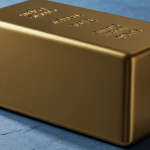 Polierter Goldbarren auf kühlem Schieferuntergrund – Symbol für Goldpreisschwankungen