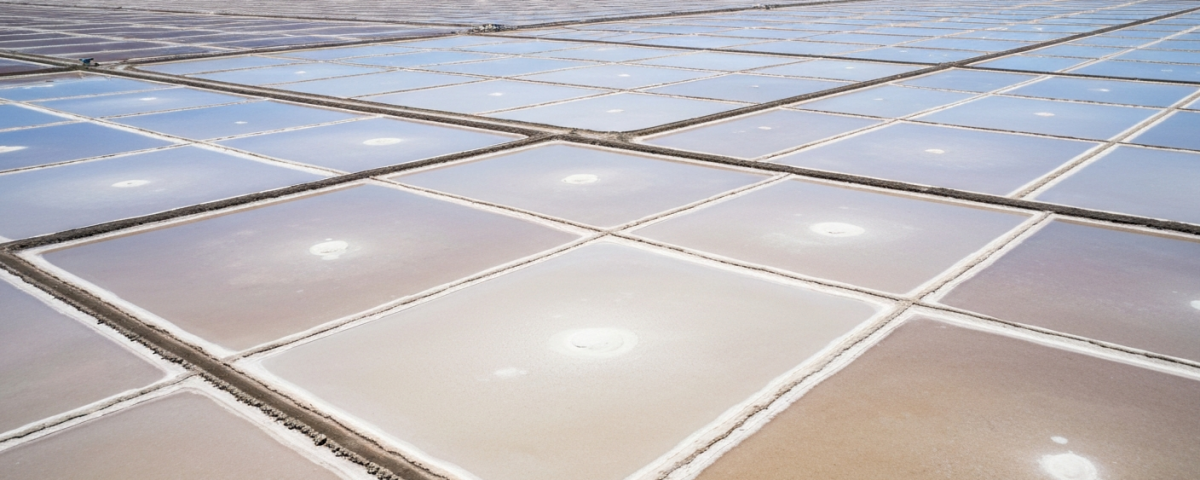 Vogelperspektive auf Lithium-Evaporationsteiche im Salar-Hochland mit weißer Salzkruste und blauem Himmel