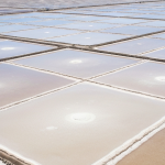 Vogelperspektive auf Lithium-Evaporationsteiche im Salar-Hochland mit weißer Salzkruste und blauem Himmel