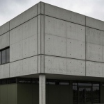 Grau betoniertes Ministeriumsgebäude unter bedecktem Himmel, gedämpfte Farben, redaktioneller Stil