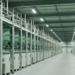 Innenansicht einer Seltene-Erden-Verarbeitungsanlage mit Mixer-Settler-Tanks unter neutralem Industrielicht