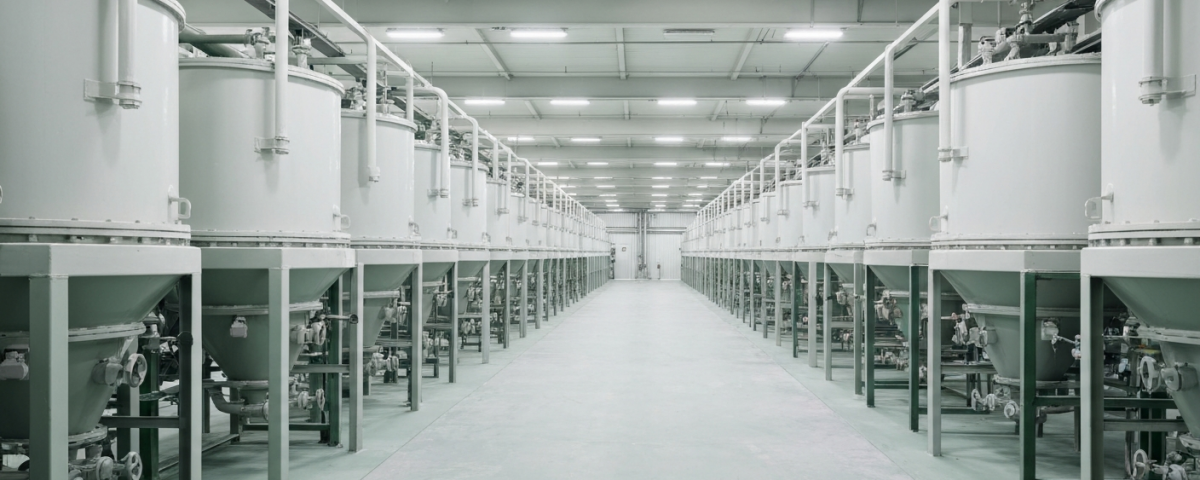 Innenansicht einer Seltenerden-Verarbeitungsanlage mit Mixer-Settler-Tanks unter neutralem Industrielicht