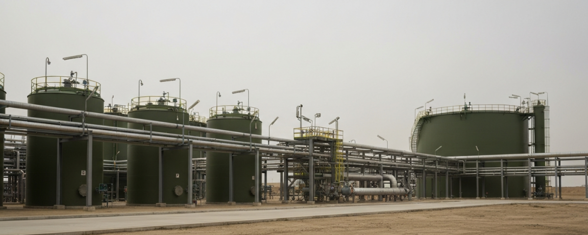 Industrielle Phosphat-Verarbeitungsanlage mit grünen Tanks und grauen Rohrsystemen unter bewölktem Himmel