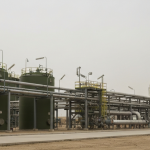 Industrielle Phosphat-Verarbeitungsanlage mit grünen Tanks und grauen Rohrsystemen unter bewölktem Himmel