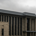 Regierungsgebäude-Außenfassade unter bedecktem Himmel, grau-grüne Palette