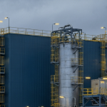 Uranverarbeitungsanlage unter bewölktem Himmel in stahl-blauer und betongrauer Industrieatmosphäre