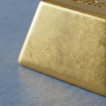 Polierter Goldbarren auf grauer Schieferoberfläche – Symbol für strukturierte Projektfinanzierung im Goldsektor