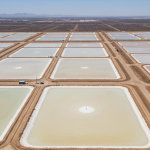 Luftaufnahme eines Lithium-Eindampfungsbeckens in der Wüste mit geometrischen Teichen in Beige und Hellblau