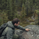 Geologe kartiert Gesteinsaufschluss im borealen Wald Ontarios mit REE-Proben