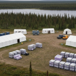 Explorationscamp im subarktischen Kanada mit Zelten und Ausrüstung inmitten borealer Landschaft