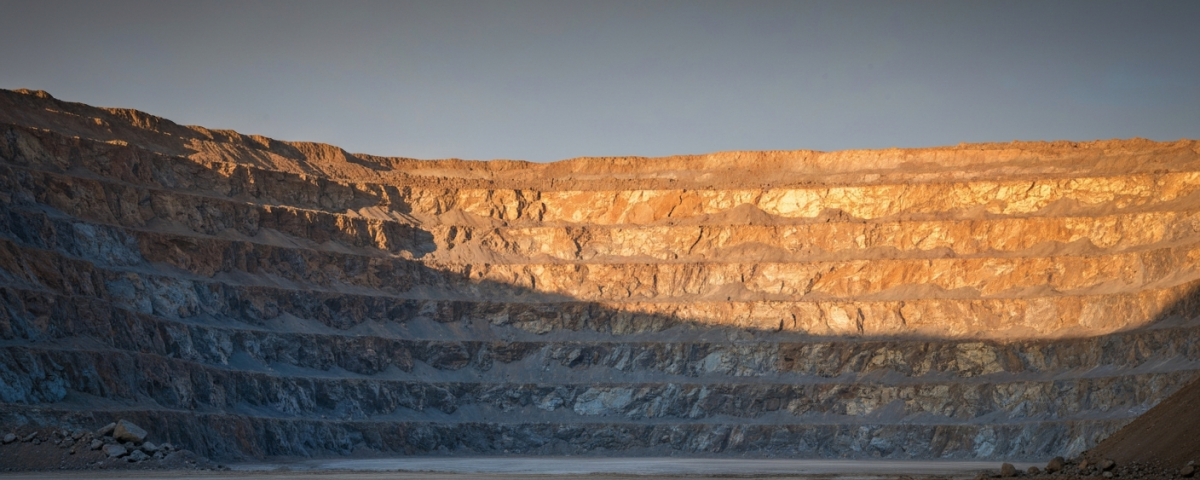 Goldtagebau in der blauen Stunde mit kühlen Schatten und matten Goldtönen an den Erzwänden