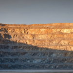 Goldtagebau in der blauen Stunde mit kühlen Schatten und matten Goldtönen an den Erzwänden