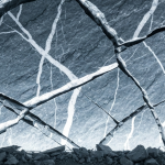 Brekzienzone mit silberhaltiger Mineralisierung in einem Untertagestollen, kaltes Licht betont silber-graue Gesteinsstru