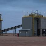 Uranverarbeitungsanlage in der namibischen Wüste unter bewölktem Himmel in Stahlblau und Betongrau