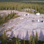 Luftaufnahme eines geologischen Erkundungsgebiets im borealen Wald Québecs mit hellen Felsaufschlüssen