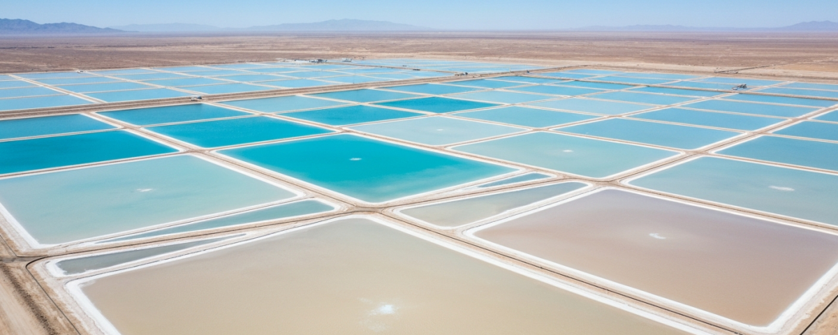 Luftaufnahme eines Lithium-Verdunstungsteich-Komplexes in der Wüste mit geometrischen Teichen in Blau und Beige