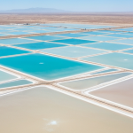 Luftaufnahme eines Lithium-Verdunstungsteich-Komplexes in der Wüste mit geometrischen Teichen in Blau und Beige