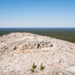 Luftaufnahme eines Pegmatit-Aufschlusses in der kanadischen Boreal-Landschaft unter klarem Tageslicht