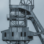 Historisches Fördergerüst einer schwedischen Mine unter bedecktem Himmel in kühlem Grau-Silber-Licht