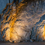 Unterirdischer Goldminengang mit Quarzader in grauem Gestein, warme Gold- und Bronzetöne
