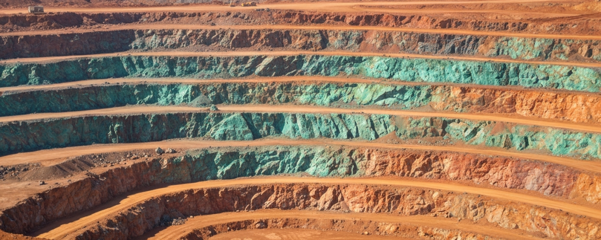 Luftaufnahme eines Kupfer-Nickel-Tagebaus mit terrassierten Felswänden und grün-türkiser Malachit-Oxidation