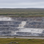 Weitwinkelaufnahme eines Seltene-Erden-Tagebaus in subarktischer Landschaft mit kühler Lichtgebung