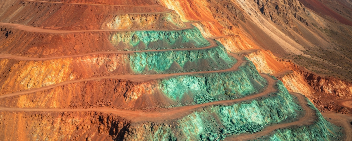 Bergige Landschaft mit freigelegten Kupfererzadern und grüner Malachit-Oxidation im Tethyan-Belt-Korridor