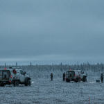 Geophysikalisches MT-Survey-Team bei der Feldarbeit in borealer Landschaft unter bedecktem Himmel