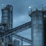 Uranmühle von außen unter bedecktem Himmel – industrielle Stahlblau- und Betongrau-Palette