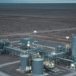 Abgelegene Uranverarbeitungsanlage in patagonischer Wüstenlandschaft unter stahlblauem Himmel