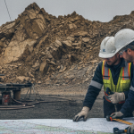 Geologen analysieren Kartenmaterial an einem Bohransatz im Goldrevier – symbolisch für Earn-in-Partnerschaften