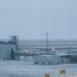 Uranverarbeitungsanlage in Wüstenlandschaft unter bewölktem Himmel, Stahl-blau und Betongrau