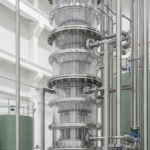Seltenerd-Extraktionsanlage mit grünen Chemikalienbehältern und violetten Oxidrückständen
